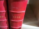 deux livres rouges posés sur une étagère d'une bibliothèque