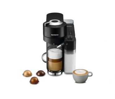gros plan d'une tasse de café à côté d'une cafetière
