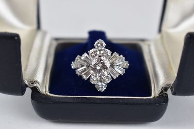 une photo d'une bague en diamant dans un écrin posé sur une surface blanche