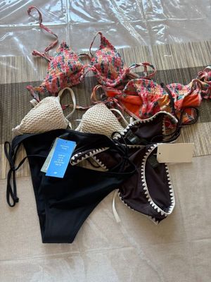 deux bikinis posés par terre à côté d'un sac en plastique