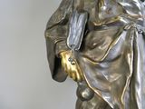 une statue représentant un homme tenant un éventail et un livre