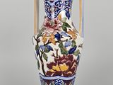 a vase with a handle that has flowers on it