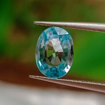 a close up of a blue diamond being held by a pair of pliers