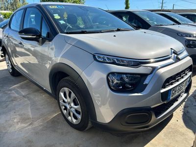 une Citroën argentée garée sur un parking à côté d'autres voitures