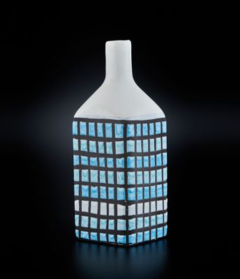 un vase blanc orné de carrés bleus sur un fond noir