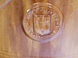 a large wooden vase with a crest on it