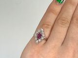 a woman ' s hand with a ring and a green and white striped manicure
