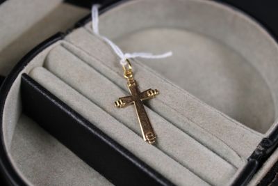 a gold cross on a ring in a black box