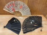 two black fans sitting on a table next to each other
