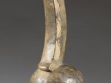 une image représentant une sculpture en bois représentant une longue corne percée d'un trou au milieu