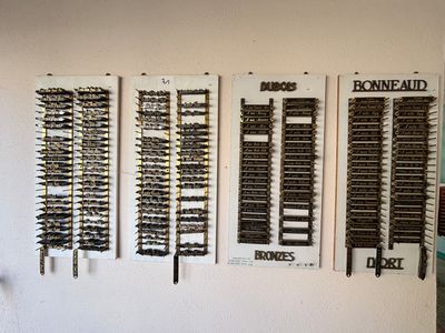 un mur sur lequel sont accrochés tout un tas d'armes à feu de différents types