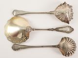 three spoons and spoon spoons sitting on a white surface