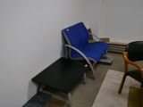 une chaise bleue et une table noire dans un coin de la pièce
