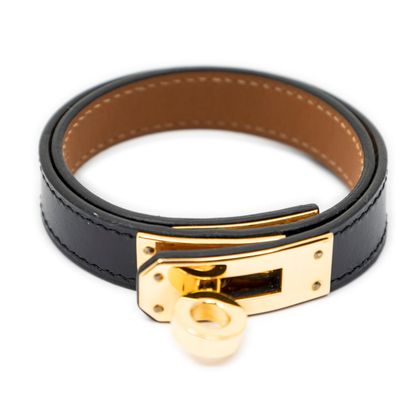 a close up of a black leather bracelet with a gold clasp