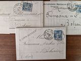 three envelopes with stamps on them sitting on a wooden table