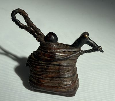 une petite statue représentant un oiseau perché sur un panier en fil de fer