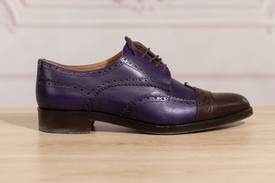 the purple shoes are on a wooden table with a white wall in the background