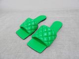 pair of green plastic slippers with a knot on the toe
