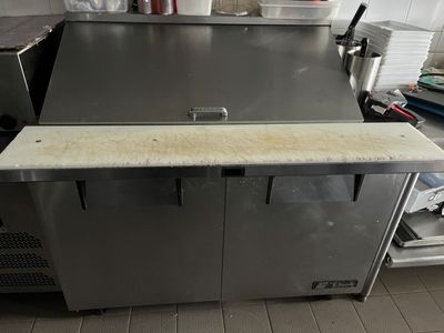 stainless steel counter top in a commercial kitchen with lots of clutter