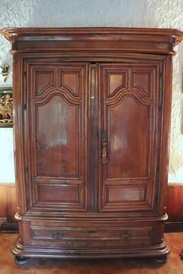 a large wooden cabinet with a mirror on top of it