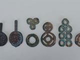 un ensemble de cinq objets métalliques anciens posés sur une surface blanche