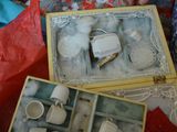 a small box with a tea set inside of it