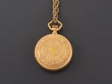 a close up of a gold pocket watch on a chain