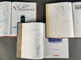 several books are open on a table with drawings on them