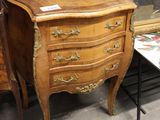 une petite commode en bois posée à côté d'une table