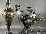 three vases and a candelab with flowers on them