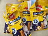 three bags of dog treats sitting on a table next to a bag of dog treats