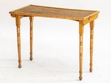 une petite table avec un plateau tressé et des pieds en bois