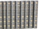 several old books are lined up in a row on a white surface