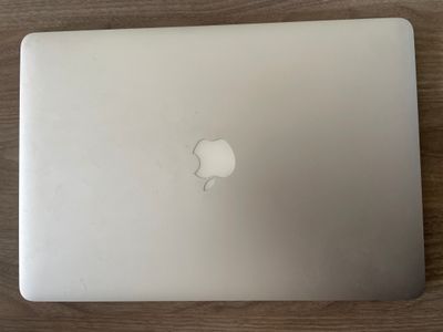 an apple laptop computer sitting on top of a wooden table