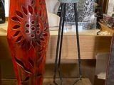 un vase rouge posé sur une table à côté d'un miroir