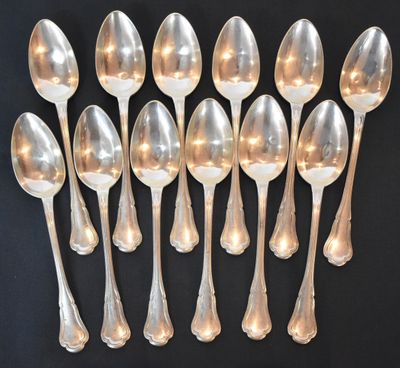 six silver spoons are arranged in a row on a black surface