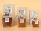 trois flacons de parfum posés les uns à côté des autres sur une table