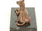 statue of a dog sitting on a black marble block