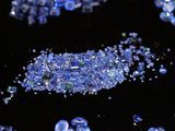 some blue crystals are scattered on a black surface