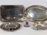a silver tray with a mirror and silver dishes on it