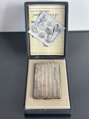 a silver cigarette case with a silver cigarette in it