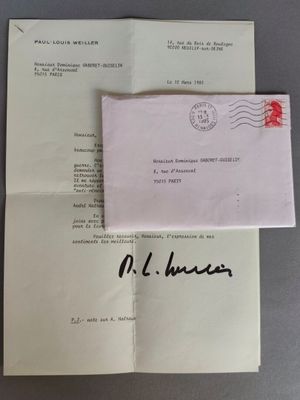 une enveloppe sur laquelle est collé un timbre, posée sur une feuille de papier