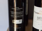 two bottles of wine sitting on a table next to each other