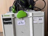 une scie circulaire à fil, de couleur verte et noire, posée sur un réfrigérateur