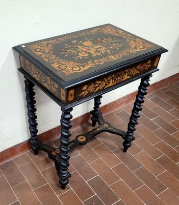 une petite table ornée d'un motif noir et doré