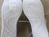 purple and white shoes with bows on them sitting on a couch