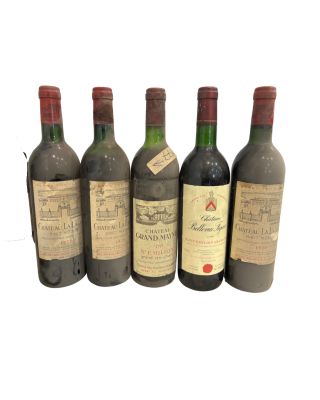 six bouteilles de vin sont alignées sur une surface blanche