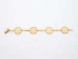 un bracelet en or jaune orné de pierres ovales sur fond blanc