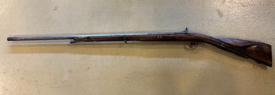 un vieux fusil fixé au mur d'une pièce