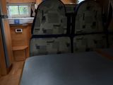 une vue de l'intérieur d'un camping-car avec une table et des chaises